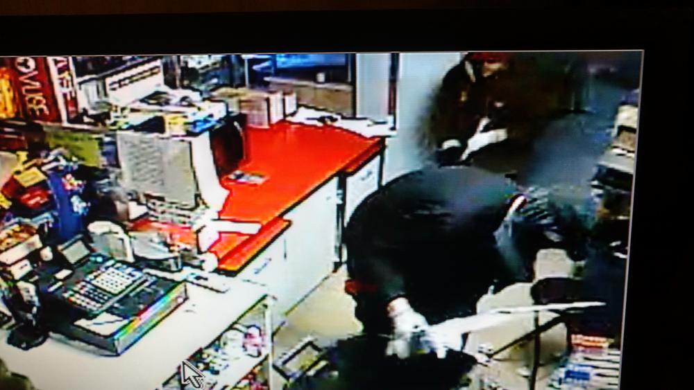 The suspect in the black jacket bent over.