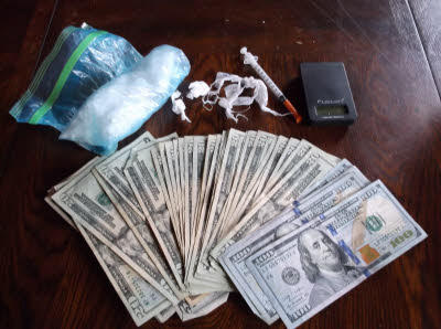 The money, drugs, and paraphernalia found during the arrest.